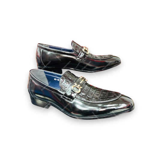 Pair of black glossy loafers with gold accents on a white background